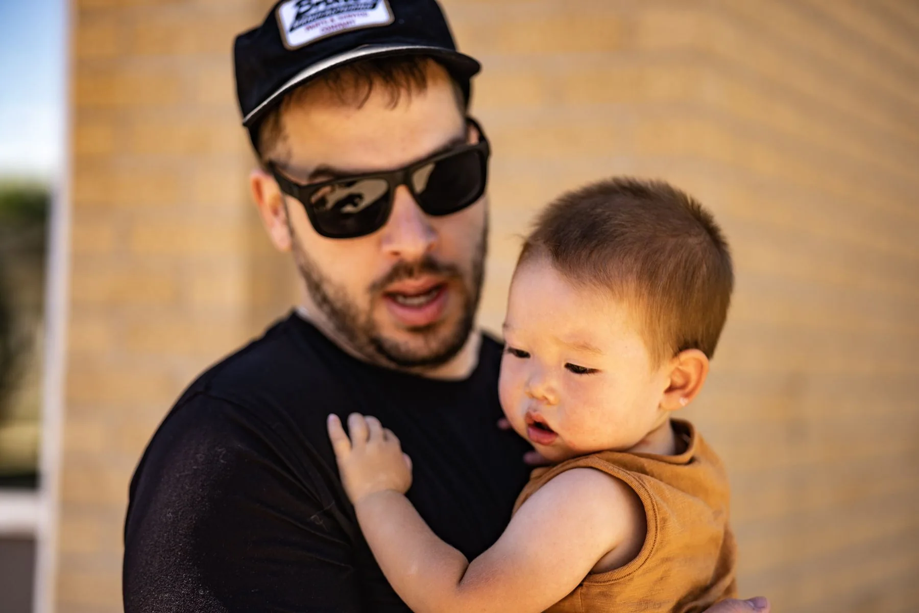 Father cuddling his young child during an outdoor portrait session