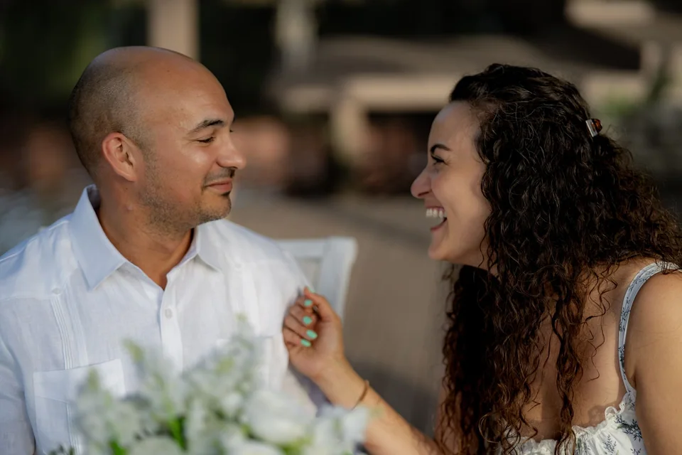 Couple smiling at each other beside a lake