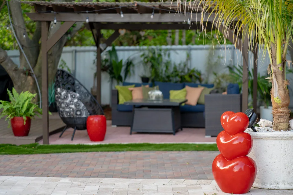 A shaded outdoor lounge beneath a pergola with string lights