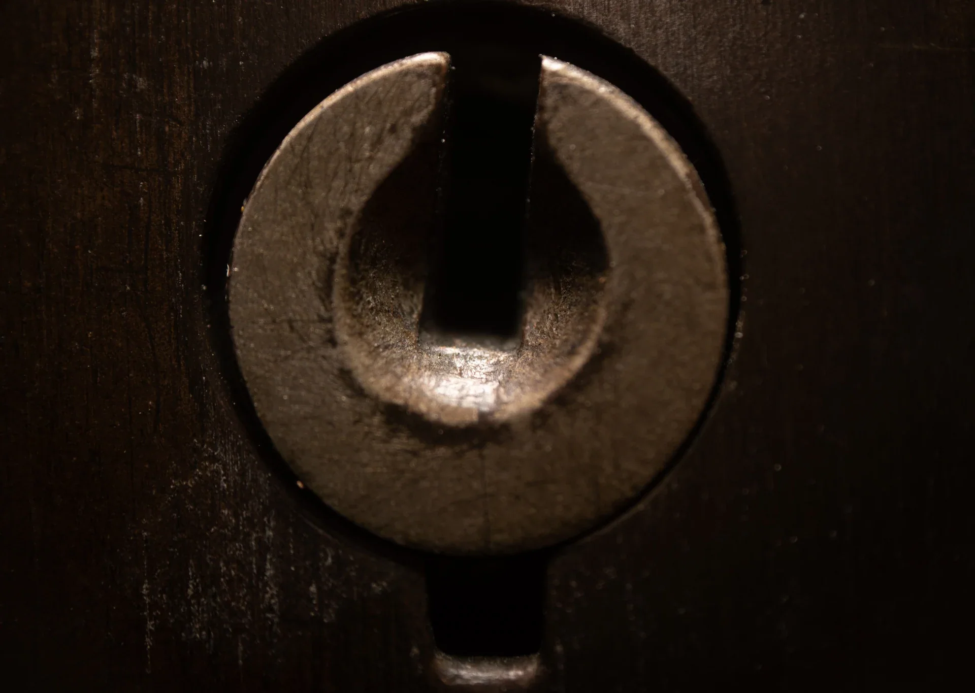 Extreme close-up of a keyhole on a dark metal surface