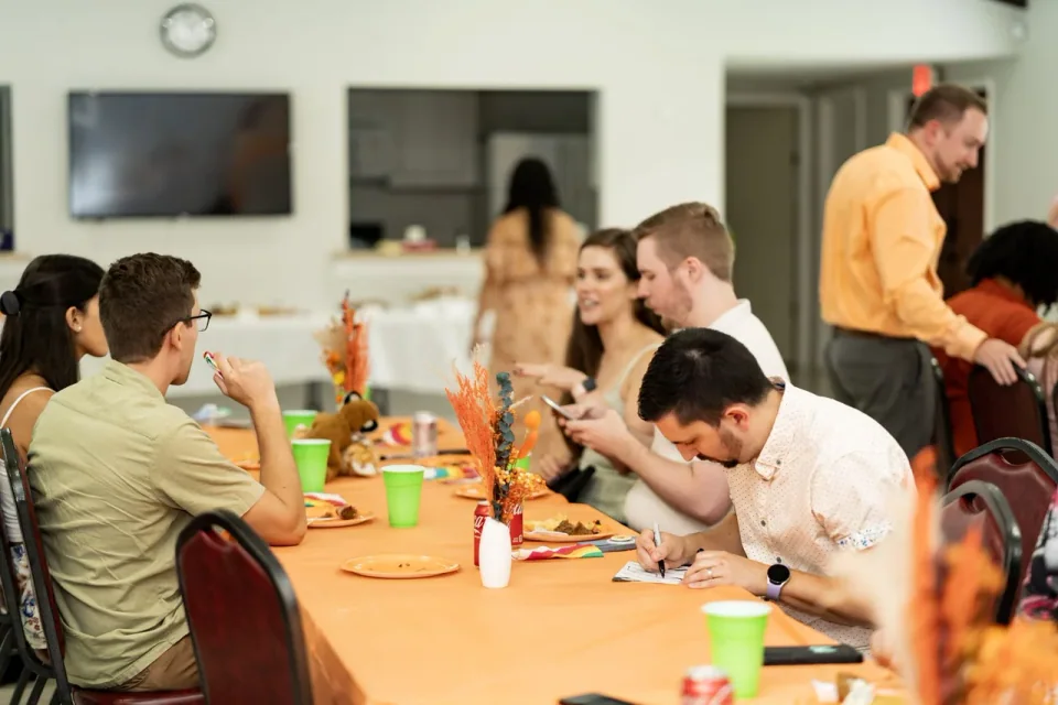 Guests making crafts together at a table during an indoor event