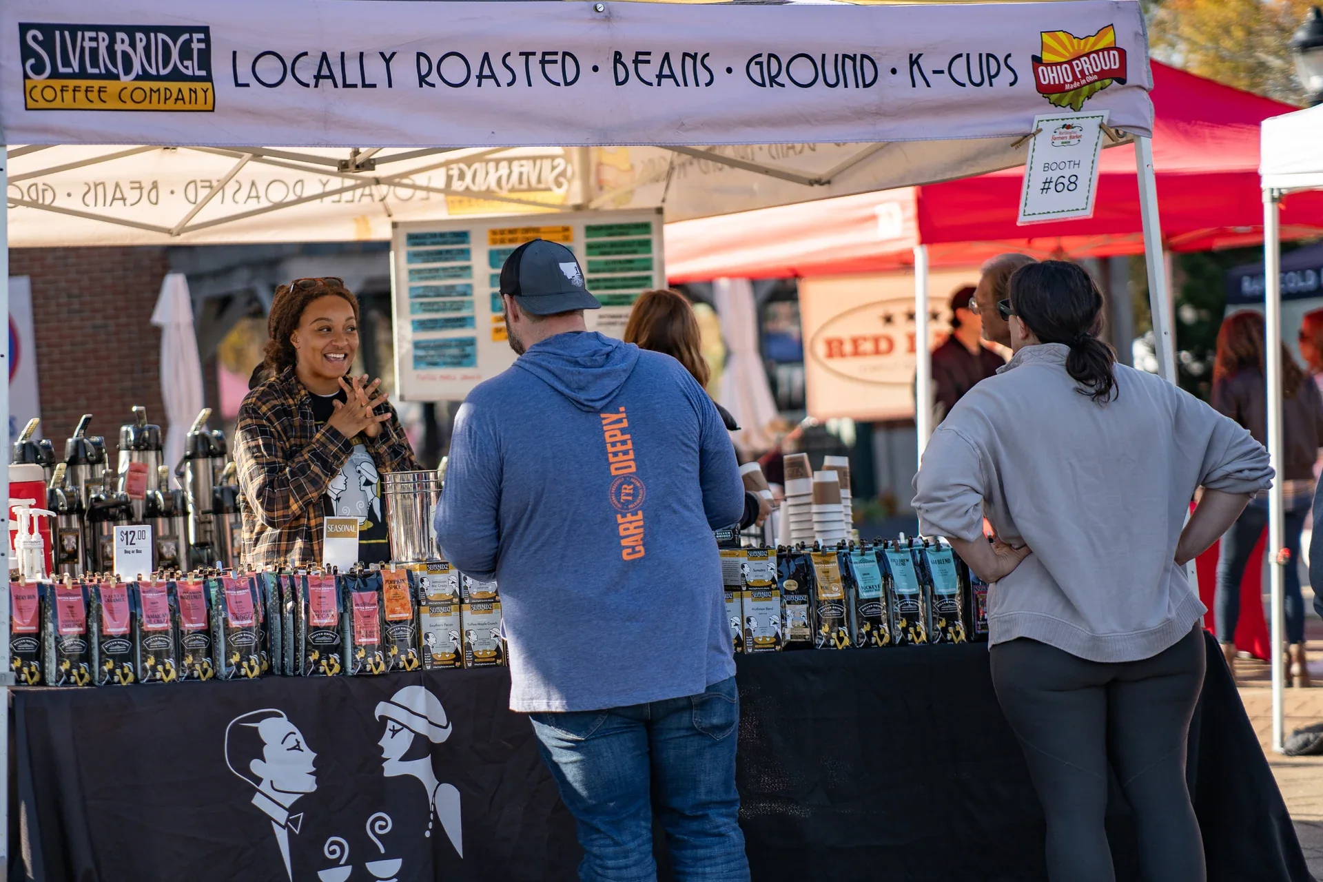 Shoppers gathered at a coffee stall with bottles and locally roasted beans