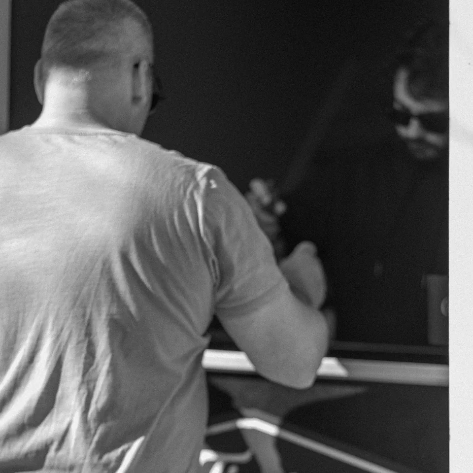 A person seen from behind at a counter, in black and white