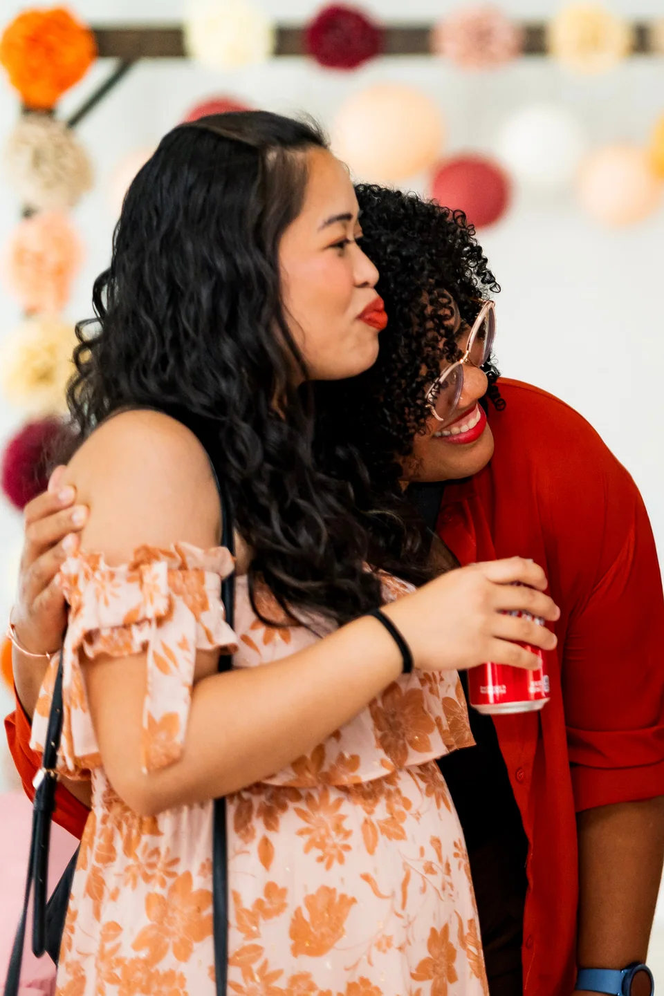 Two women sharing a spontaneous embrace at a baby shower