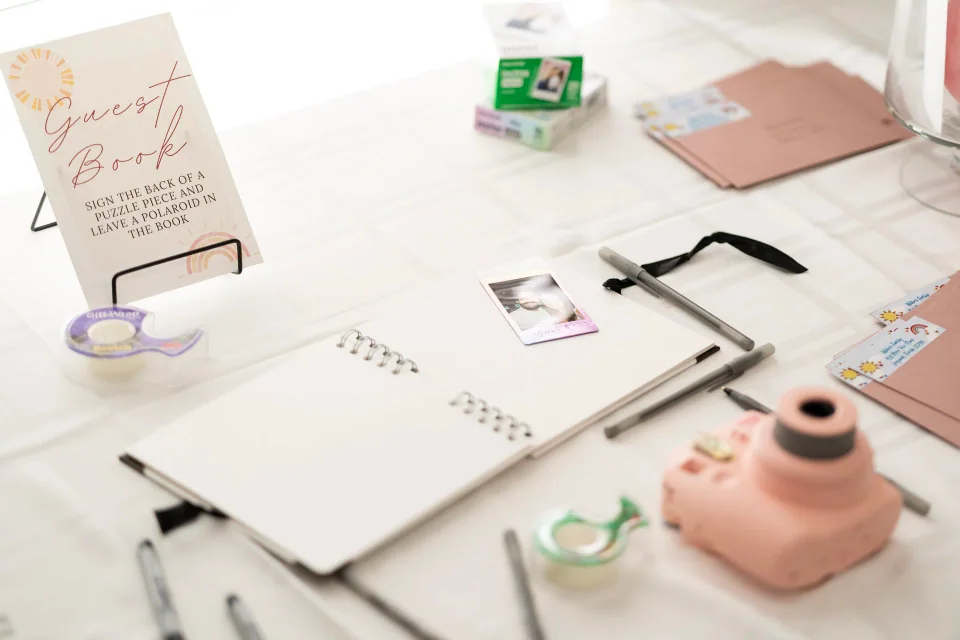 An event activity table with notebooks, cards, pens and an instant camera