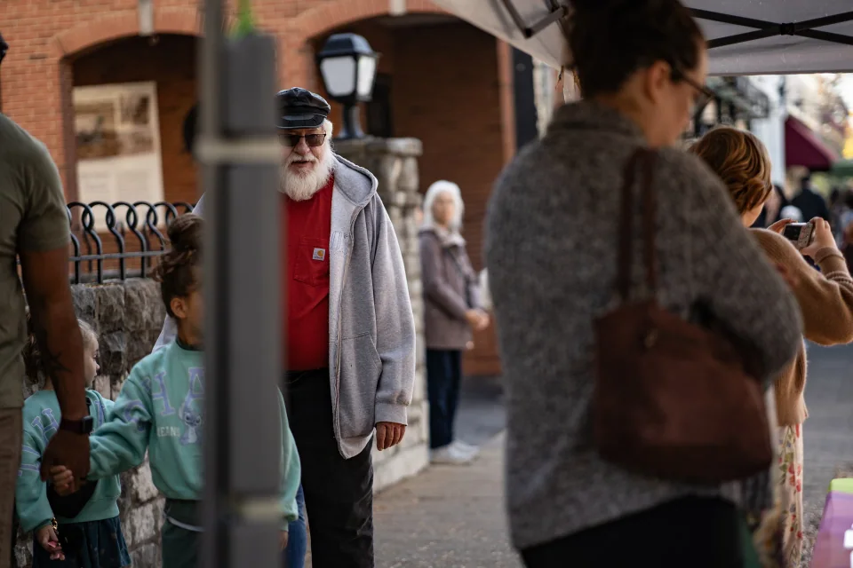 People passing one another along a shop-lined sidewalk